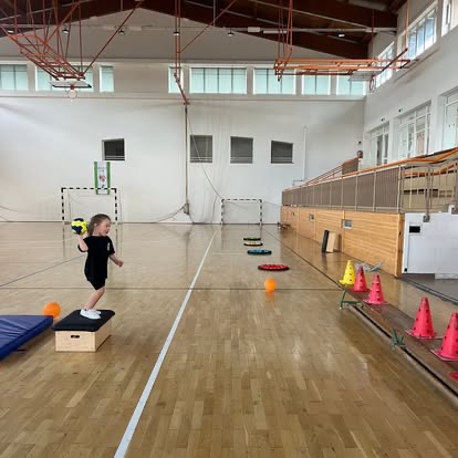 Gyermek játékos ügyességi feladat közben a tornateremben